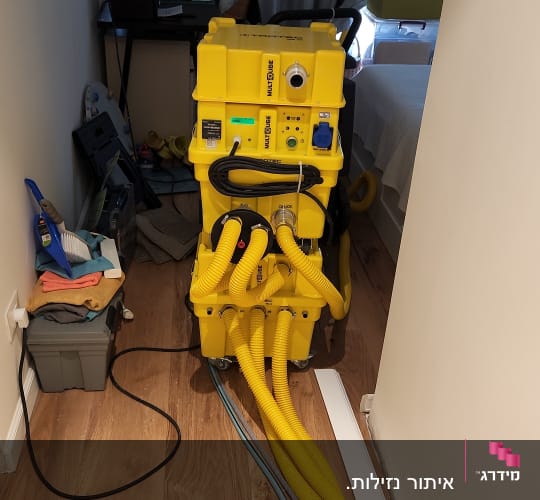 מכונה צהובה עם צינורות לגילוי נזילות מים